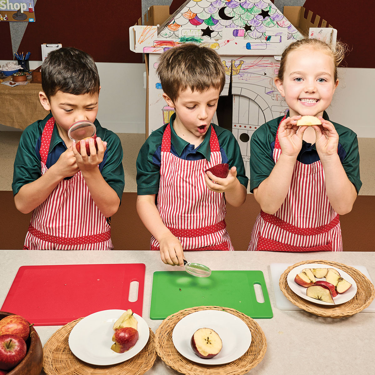 Sunshine Coast Grammar School students pretending to chop apples in the kitchen